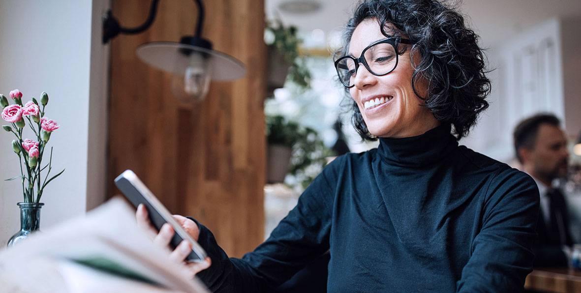 A woman looking at her mobile phone and smiling.