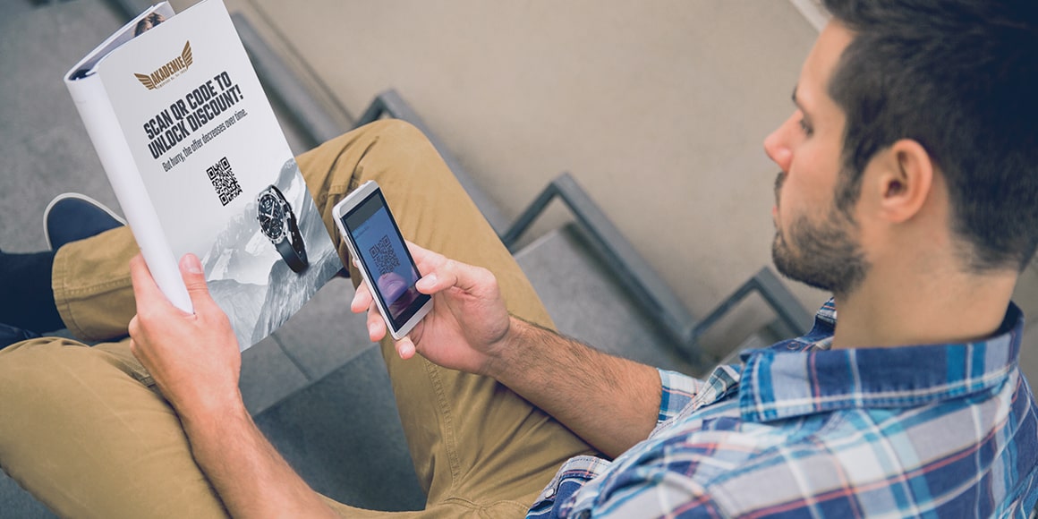 Man using a mobile phone to scan a QR code in a catalog.