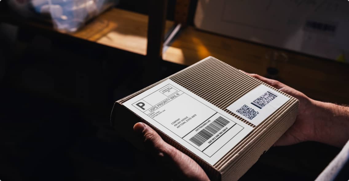 A close-up of someone holding a Priority Mail® package in their hands
