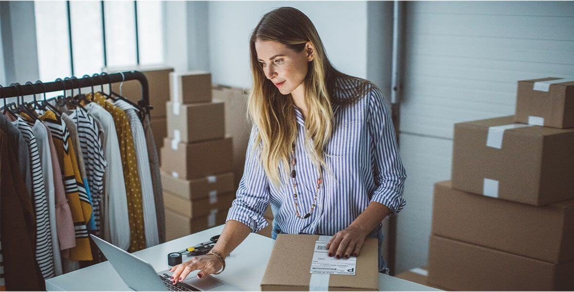 A businesswoman shipping out packages with the help of her computer.