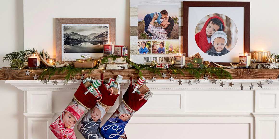 A fireplace decorated for the holiday season with family photos and stockings.