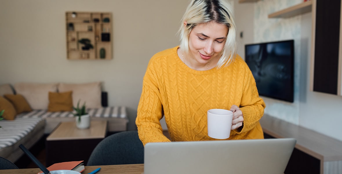 A woman dressed in yellow working on her computer.