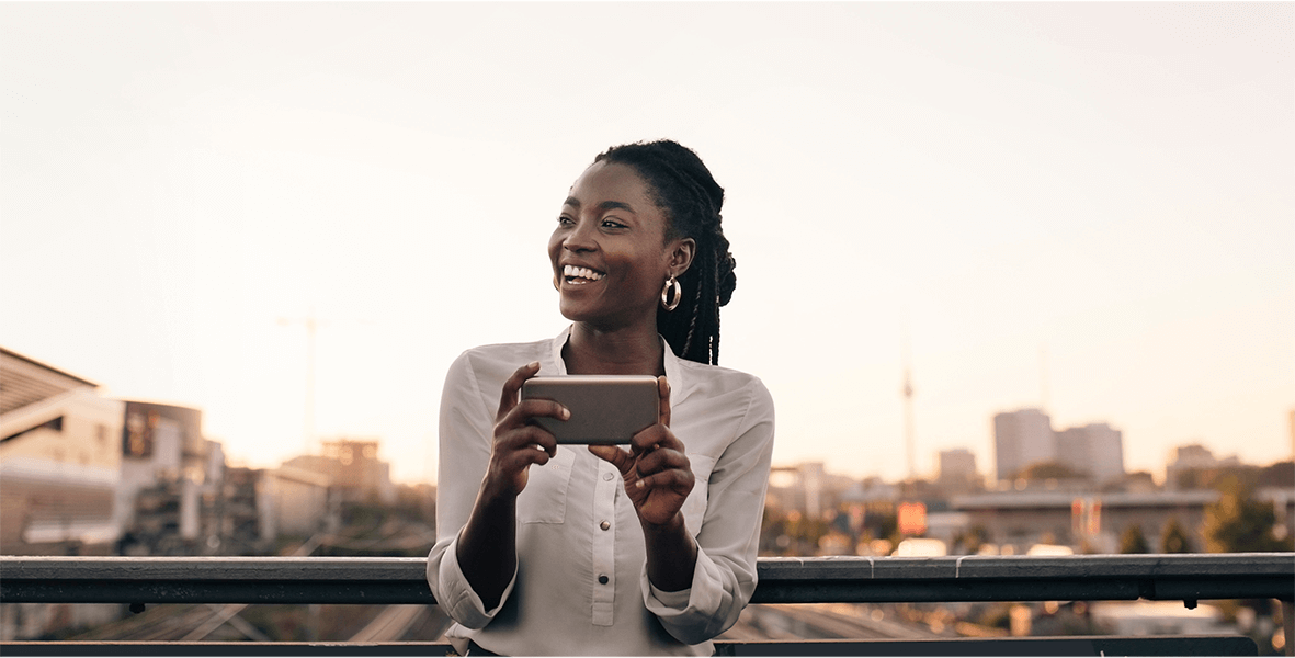 A woman laughing as she's engaged with her cell phone.