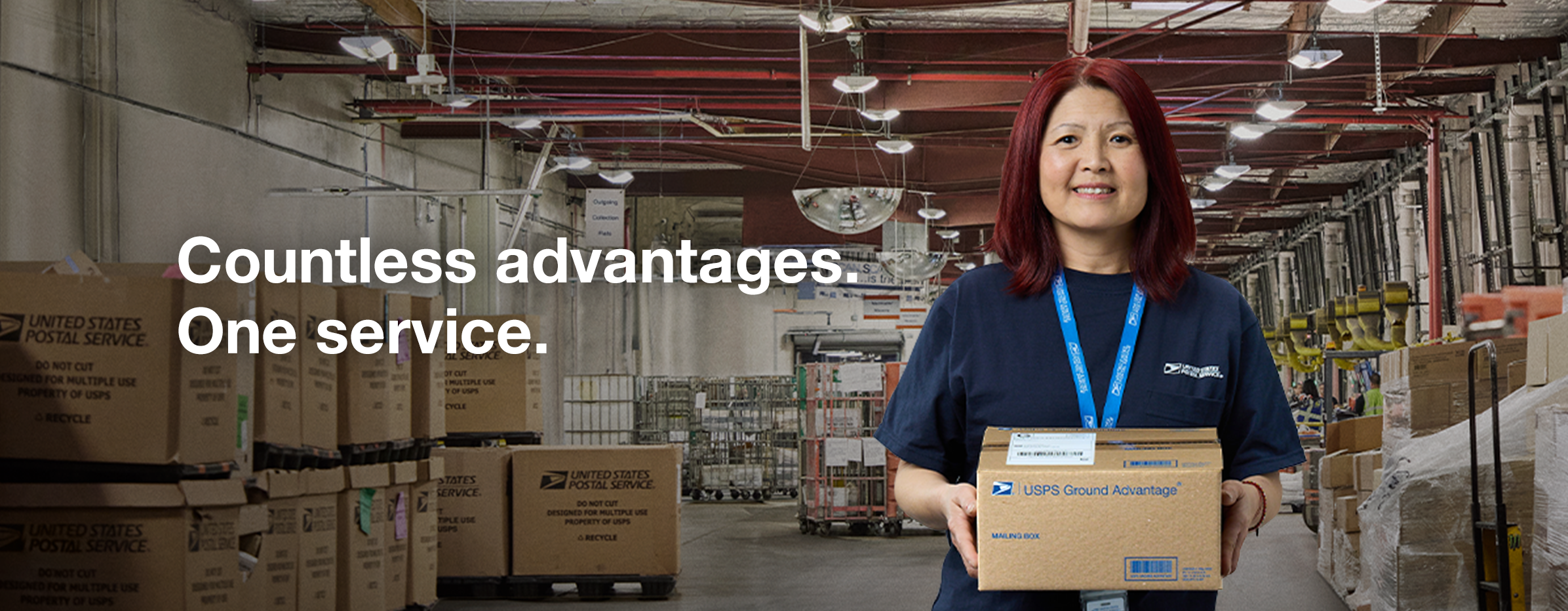 A female USPS worker carrying a brown package that has “USPS Ground Advantage®” printed on it. Image text reads “Countless advantages. One service.”