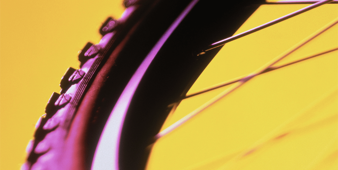 Yellow tire tread on a bicycle wheel.