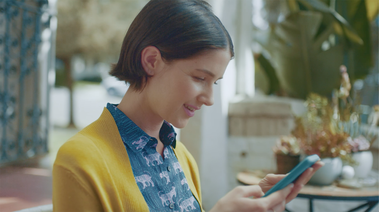 A woman looking at her mobile phone and smiling.