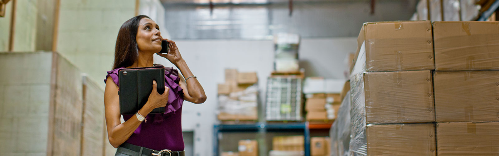 A woman on her cell phone holding a leather executive portfolio.